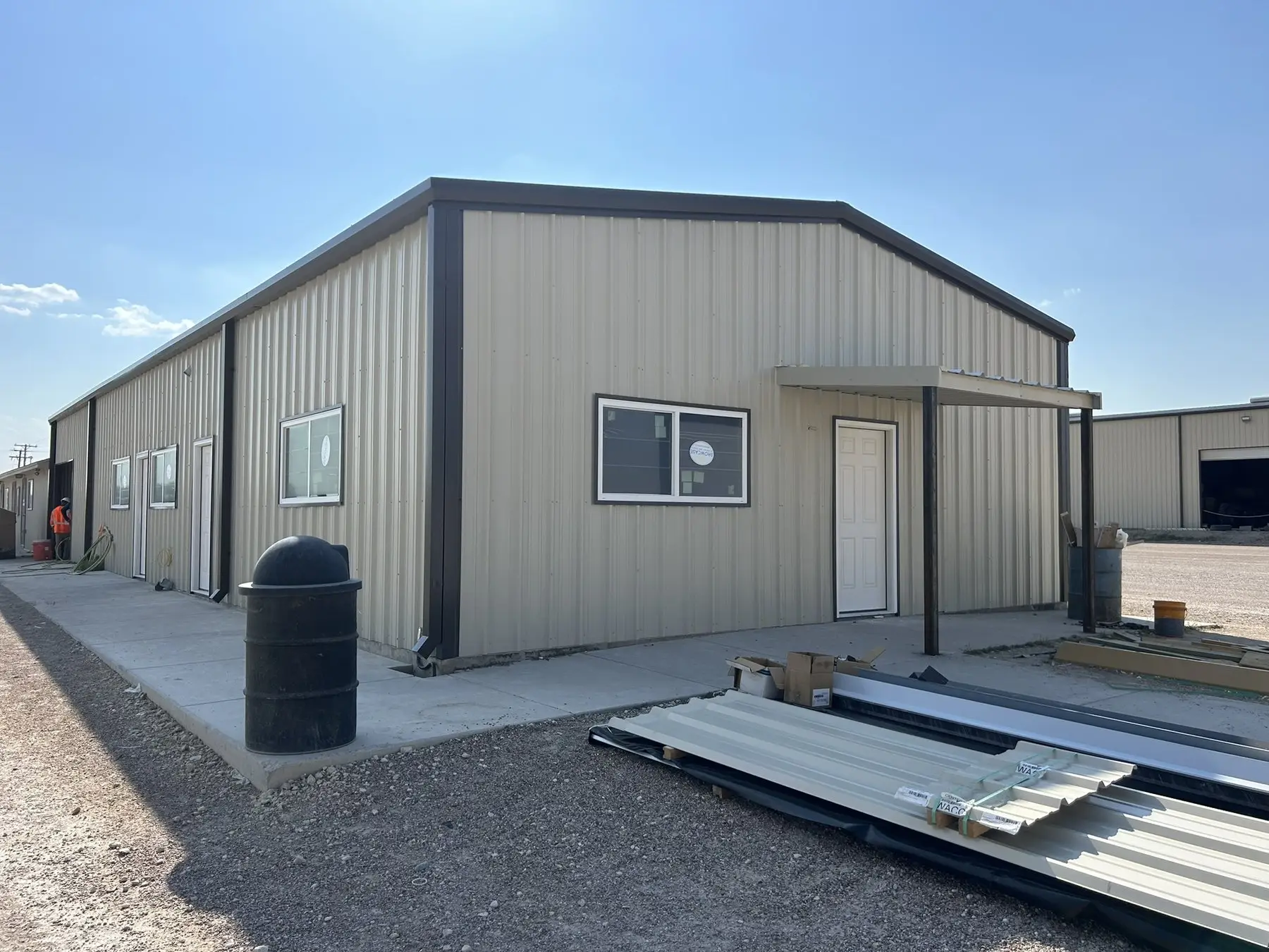 Tan barndominium with a covered side entry — built by Rodriguez Metal Buildings, Central Texas
