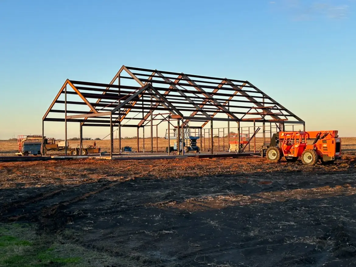 RMB crew raising a steel frame at dusk on a Central Texas jobsite
