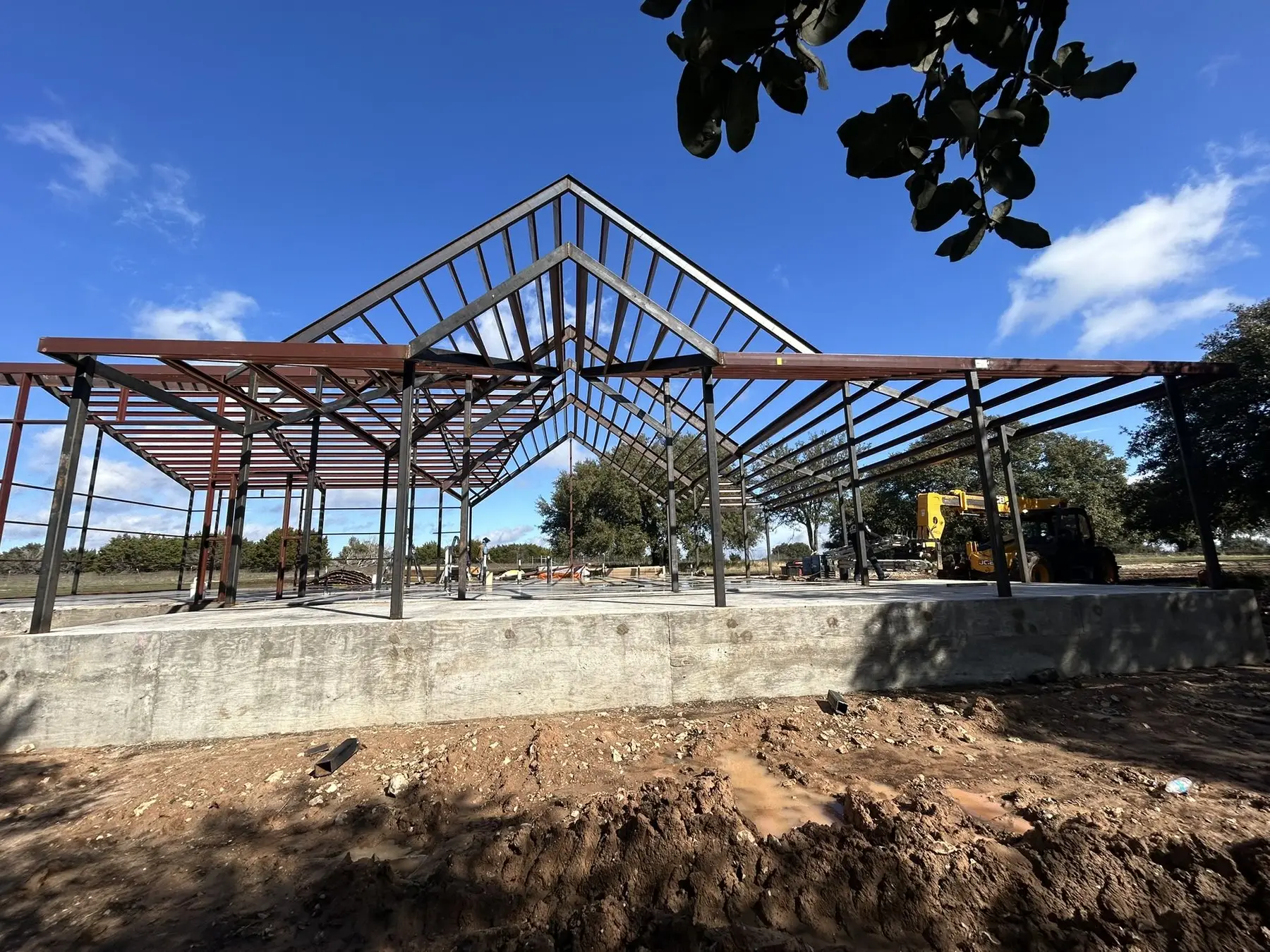 Trusses set on a new slab — custom metal buildings by RMB in in progress