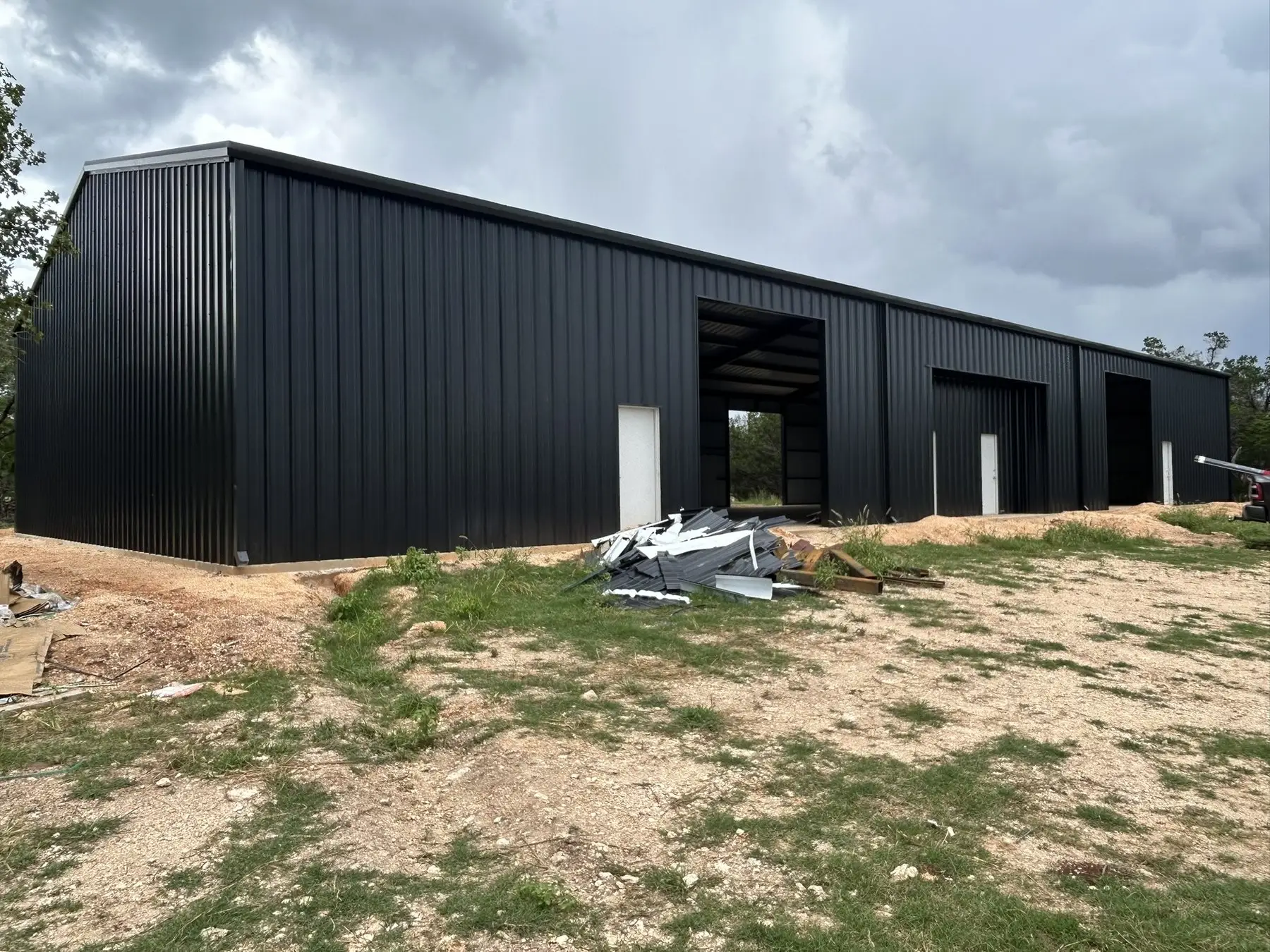 Long charcoal shop with openings framed — built by Rodriguez Metal Buildings, Central Texas