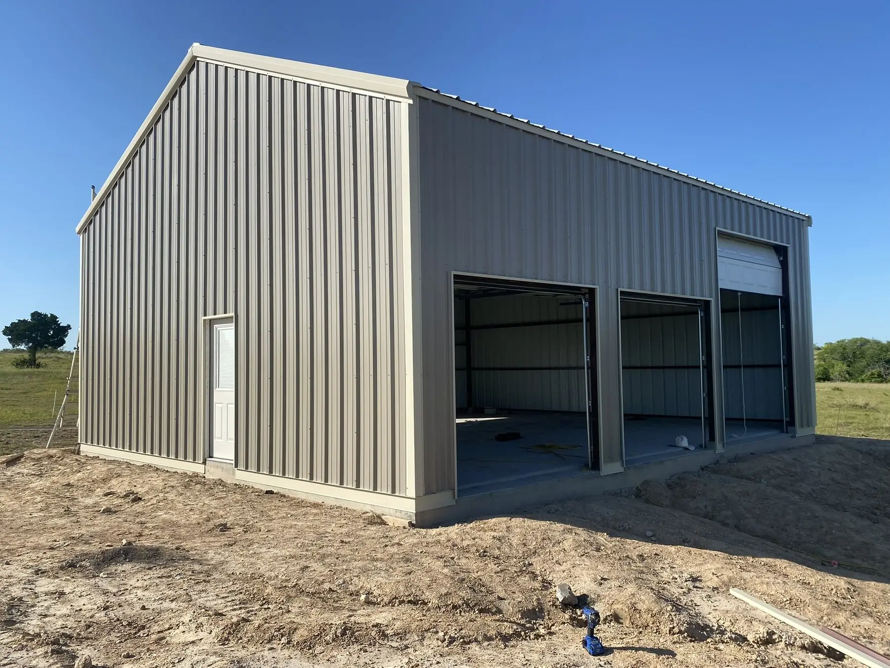 Grey shop with two equipment bays — built by Rodriguez Metal Buildings, Central Texas