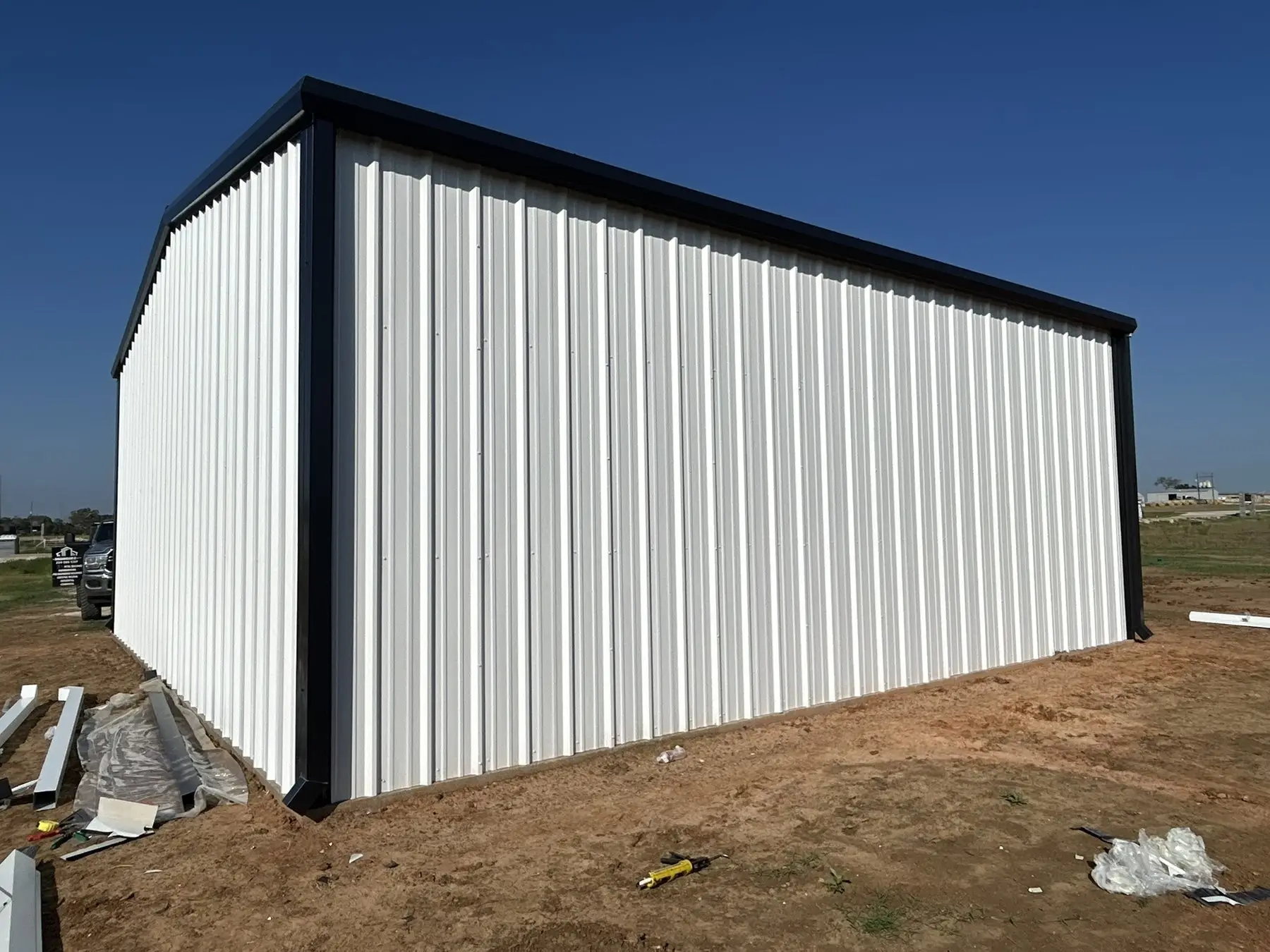 White shop with charcoal trim — built by Rodriguez Metal Buildings, Central Texas